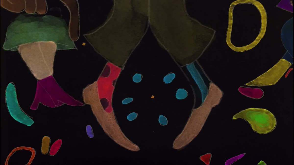 Socked feet dancing in the dark among confetti shapes